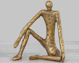 MAN SITTING with a rough gold finish. • Size: 23 X 20 X 13 cm